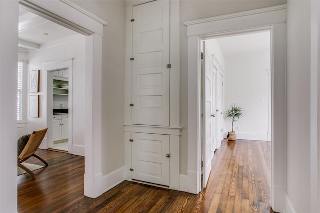 corridor with dark wood-type flooring and baseboards