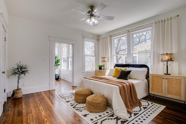 bedroom with baseboards, dark wood-type flooring, and a ceiling fan