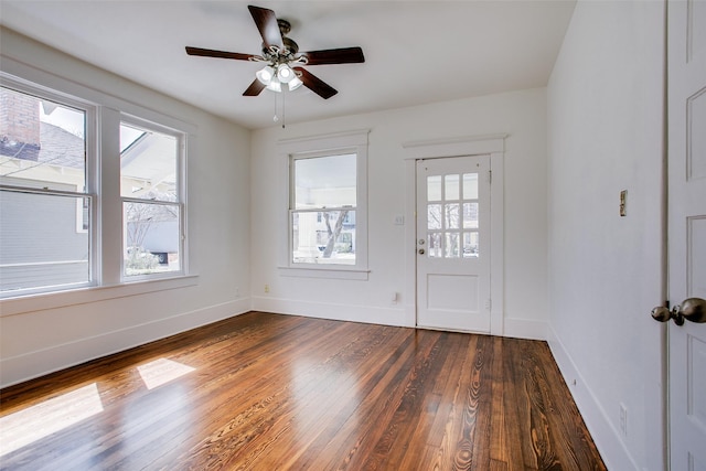 foyer entrance featuring dark wood-style floors, plenty of natural light, ceiling fan, and baseboards