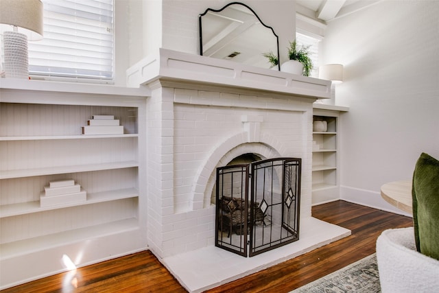 room details featuring a fireplace, baseboards, and wood finished floors