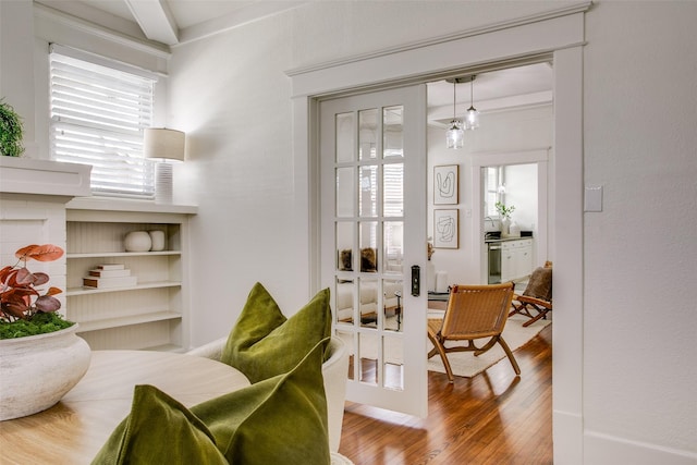 living area featuring beam ceiling and wood finished floors