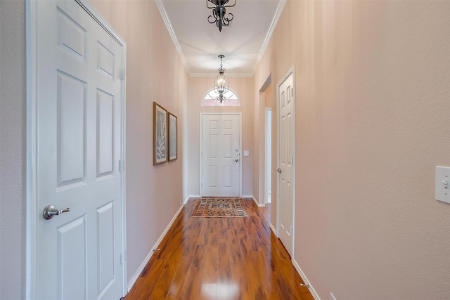 doorway to outside with crown molding, baseboards, and wood finished floors