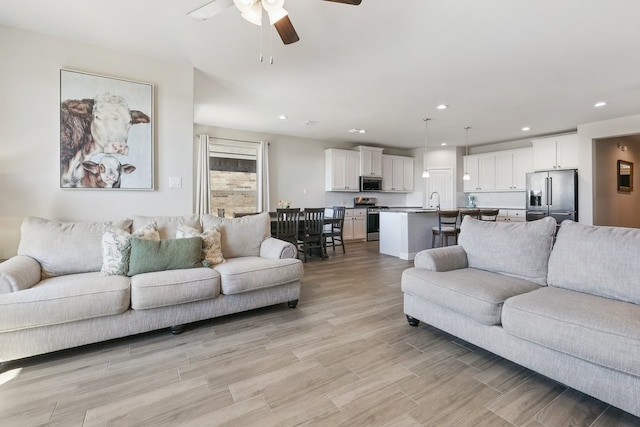 living room featuring recessed lighting, light wood finished floors, and ceiling fan