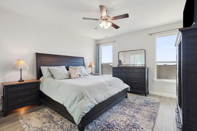 bedroom featuring light wood-type flooring, baseboards, and ceiling fan