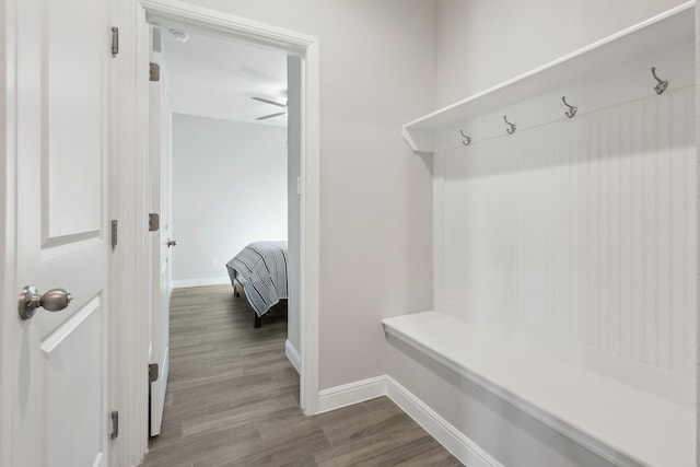 mudroom with dark wood-style floors and baseboards