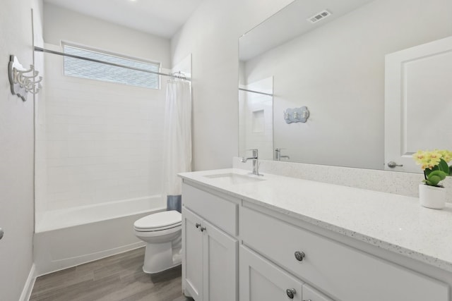 full bathroom with visible vents, toilet, shower / bath combo, wood finished floors, and vanity