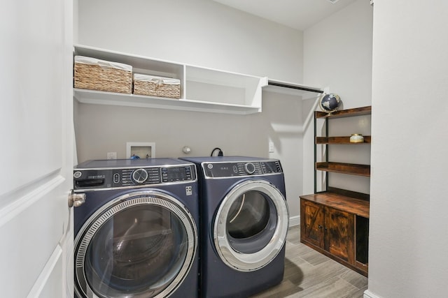 laundry room with washer and clothes dryer, laundry area, and wood finished floors