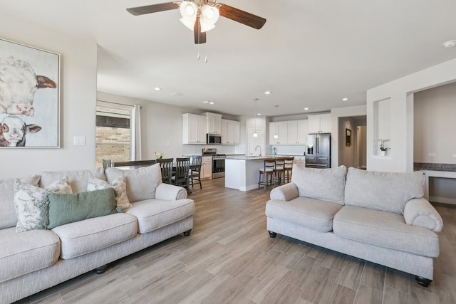 living room featuring recessed lighting, light wood-style floors, and ceiling fan