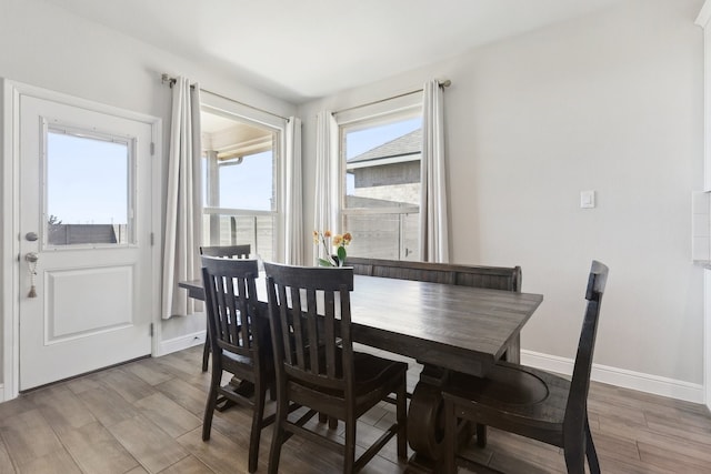 dining area featuring baseboards and light wood finished floors