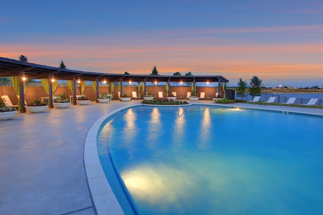 pool at dusk with a fenced in pool, fence, a pergola, and a patio area