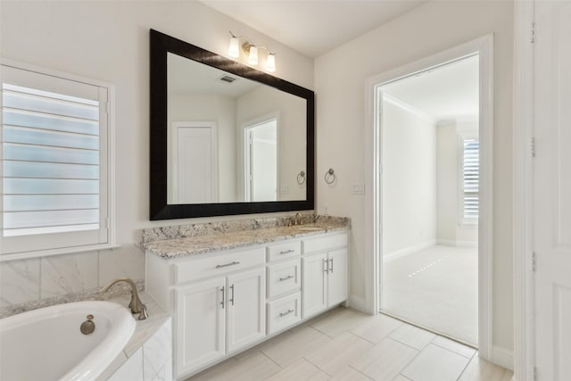 bathroom with visible vents, baseboards, a bath, and vanity