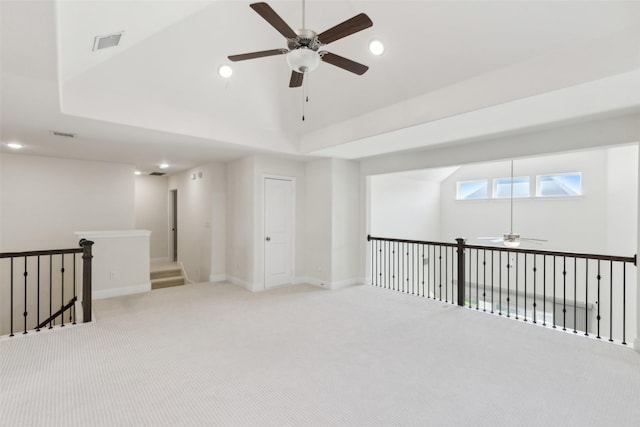 spare room featuring visible vents, light carpet, a tray ceiling, recessed lighting, and ceiling fan