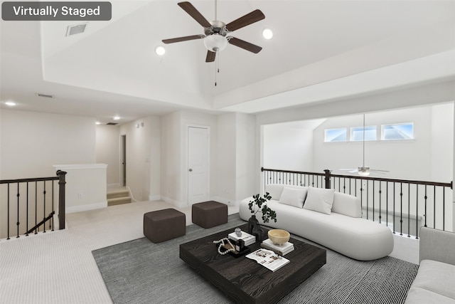 living area with visible vents, carpet flooring, recessed lighting, a raised ceiling, and a ceiling fan