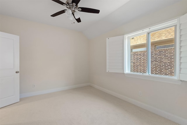 carpeted spare room with plenty of natural light, ceiling fan, baseboards, and vaulted ceiling