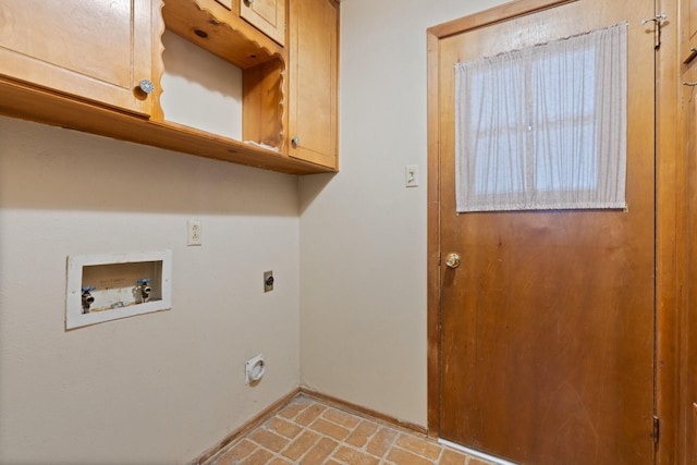 clothes washing area with baseboards, hookup for an electric dryer, cabinet space, brick floor, and washer hookup