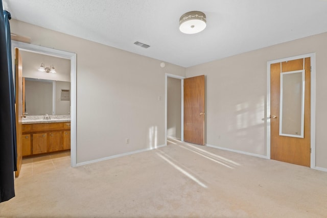 unfurnished bedroom with visible vents, light colored carpet, baseboards, and a sink