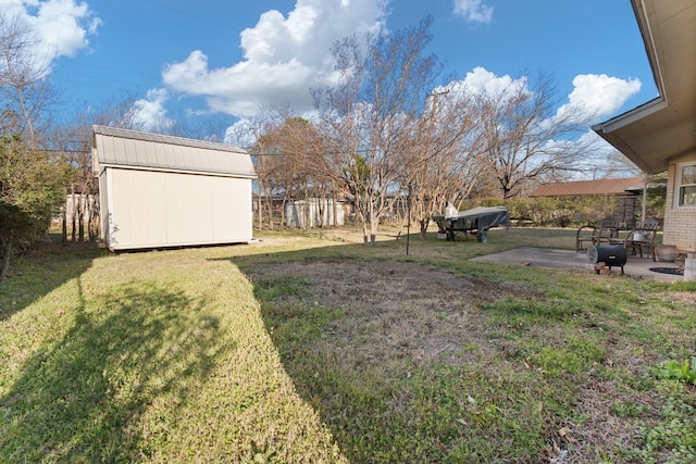 view of yard with an outbuilding, a shed, a fenced backyard, and a patio