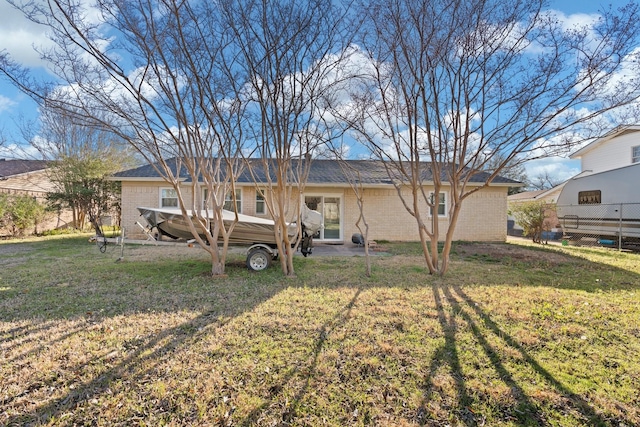 rear view of property with a yard and brick siding