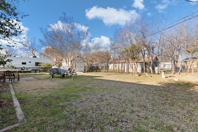 view of yard with an outbuilding, a storage unit, and fence