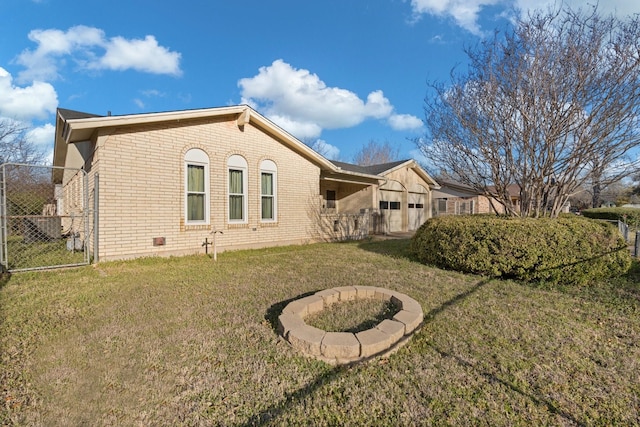 back of property featuring brick siding, a lawn, and fence