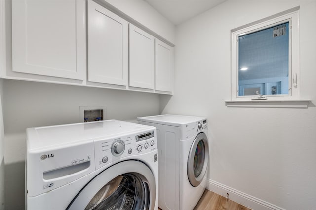 laundry area with cabinet space, washing machine and dryer, baseboards, and light wood-type flooring