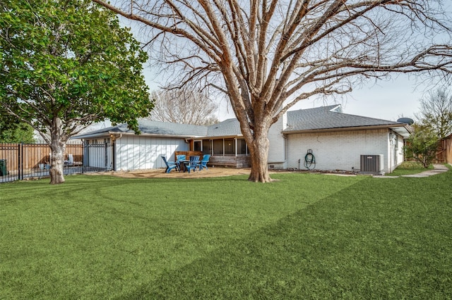 back of house featuring cooling unit, brick siding, and a lawn