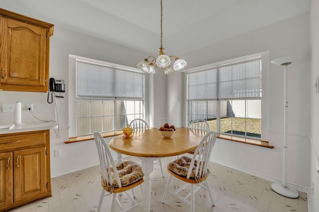 dining area with baseboards and an inviting chandelier