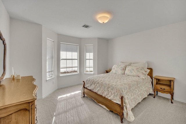 bedroom with light colored carpet, visible vents, and baseboards