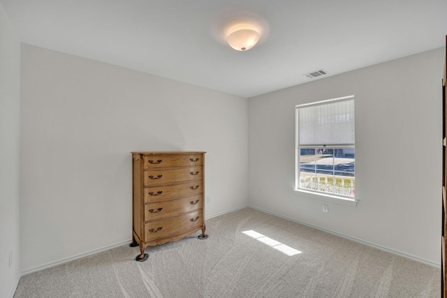 carpeted empty room featuring visible vents and baseboards