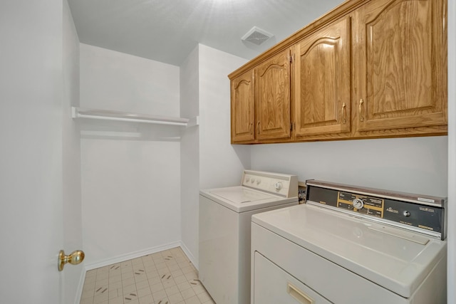 clothes washing area with washer and dryer, cabinet space, visible vents, and baseboards