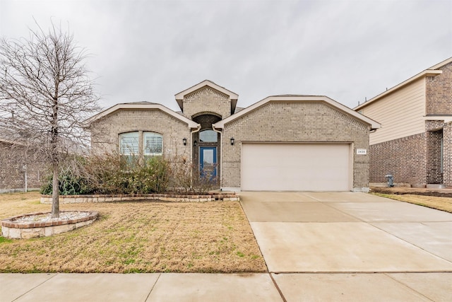 view of front of house featuring a garage, a front yard, brick siding, and driveway