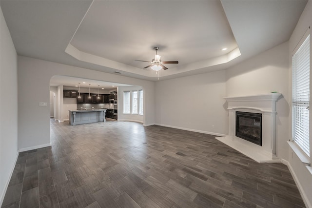 2420 Red Draw Rd, Fort Worth, TX 76177 - unfurnished living room with a glass covered fireplace, baseboards, ceiling fan, dark wood-style floors, and a raised ceiling