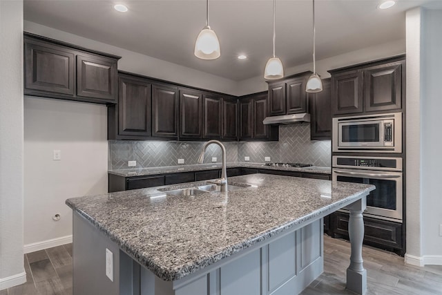 2420 Red Draw Rd, Fort Worth, TX 76177 - kitchen with a sink, baseboards, light stone counters, under cabinet range hood, and stainless steel appliances