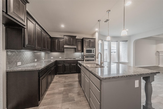 2420 Red Draw Rd, Fort Worth, TX 76177 - kitchen with visible vents, light stone countertops, arched walkways, a sink, and stainless steel appliances
