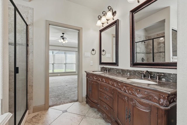 bathroom with a shower stall, double vanity, tile patterned floors, and a sink