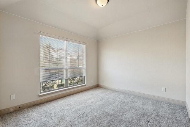 carpeted spare room featuring baseboards