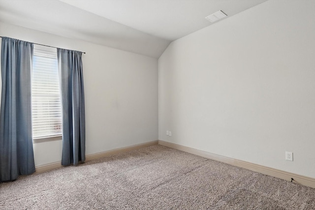 empty room with baseboards, visible vents, carpet floors, and lofted ceiling