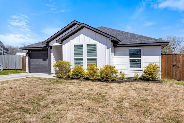 view of front facade featuring a garage, fence, board and batten siding, and driveway