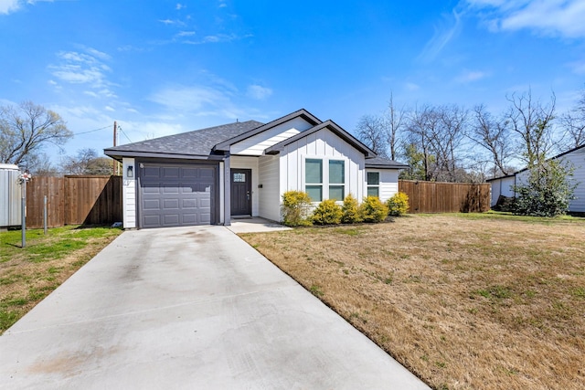 view of front of home featuring board and batten siding, a front lawn, fence, concrete driveway, and a garage