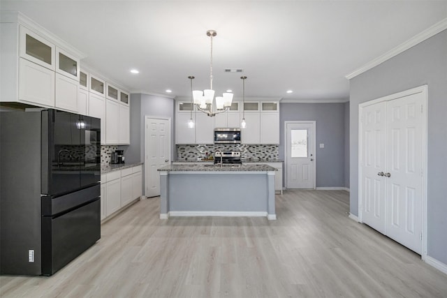 kitchen with light wood-style flooring, backsplash, white cabinetry, stainless steel appliances, and crown molding