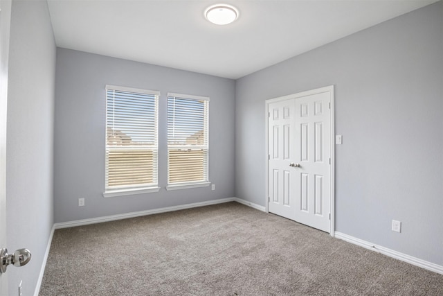 unfurnished bedroom with carpet, baseboards, and a closet