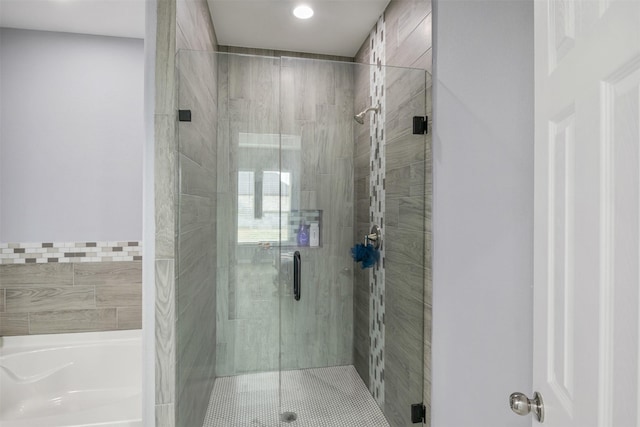 full bath featuring a stall shower and a garden tub