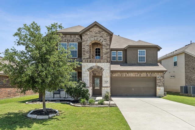 french country home with a front lawn, stone siding, brick siding, and driveway