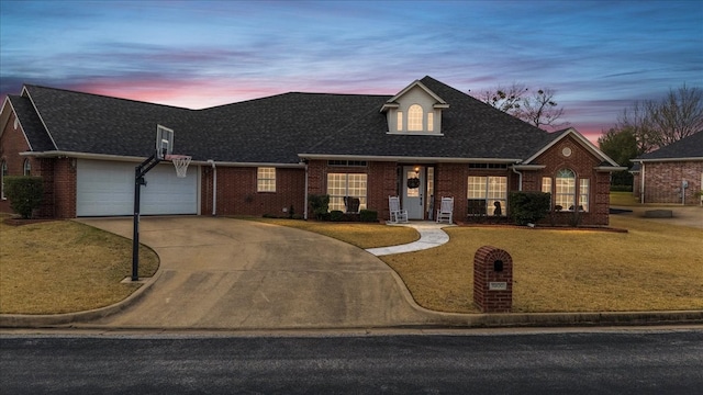 view of front of home featuring brick siding, an attached garage, concrete driveway, and a front yard