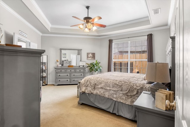 bedroom featuring visible vents, ceiling fan, light colored carpet, a tray ceiling, and ornamental molding