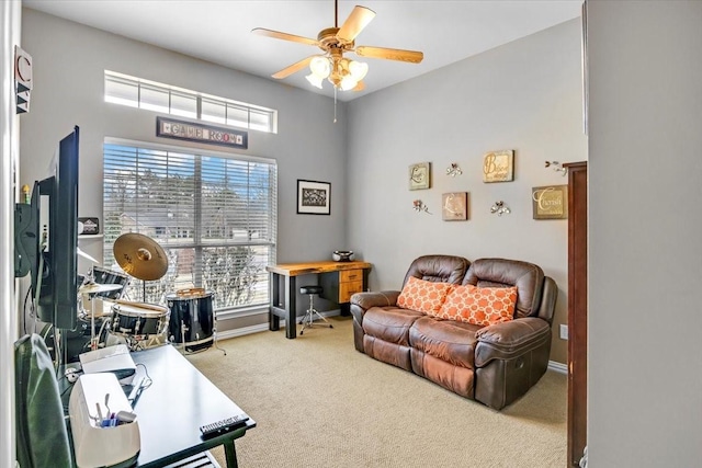 carpeted home office featuring baseboards and a ceiling fan