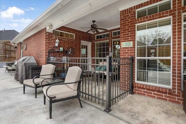 view of patio with grilling area, a ceiling fan, and fence