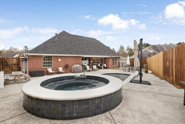 view of swimming pool with a patio, an in ground hot tub, and a fenced backyard