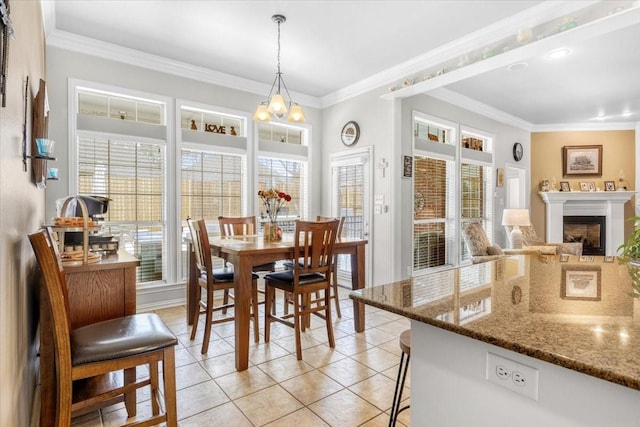 dining area featuring a wealth of natural light, crown molding, a fireplace, and light tile patterned floors