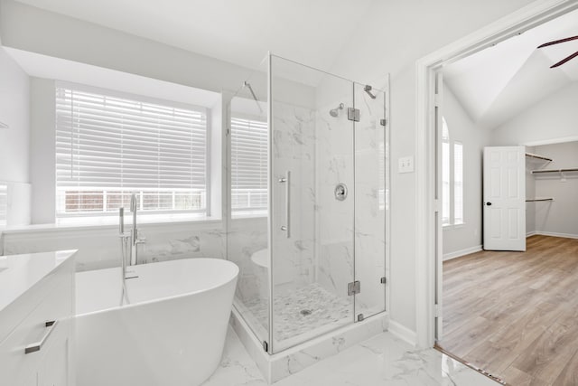 full bathroom with lofted ceiling, a freestanding tub, marble finish floor, and a marble finish shower